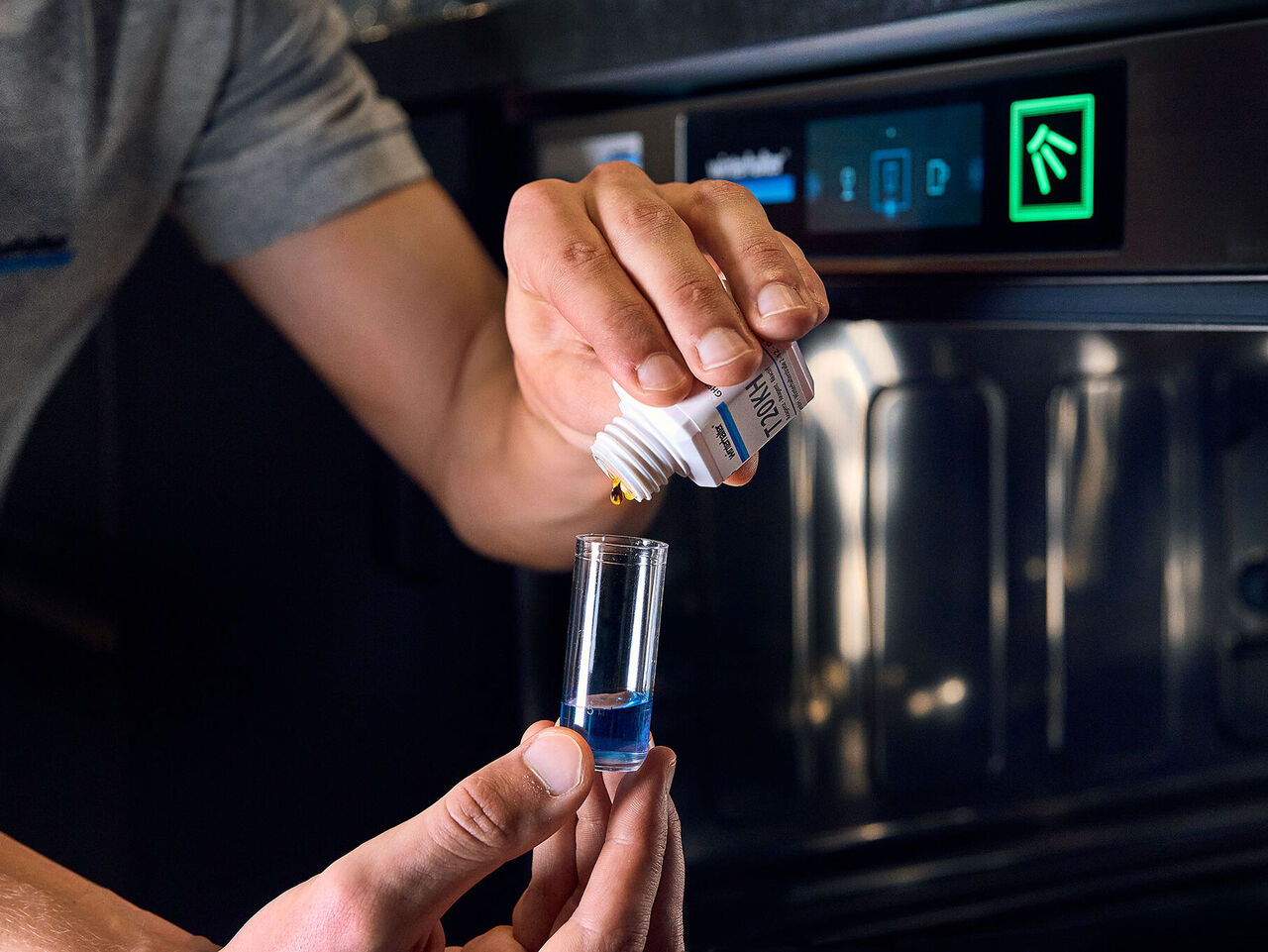 Conseils pour éviter la corrosion du verre : ajuster précisément le traitement de l'eau Un technicien de service vérifie le dispositif de traitement de l'eau comme protection contre la corrosion du verre