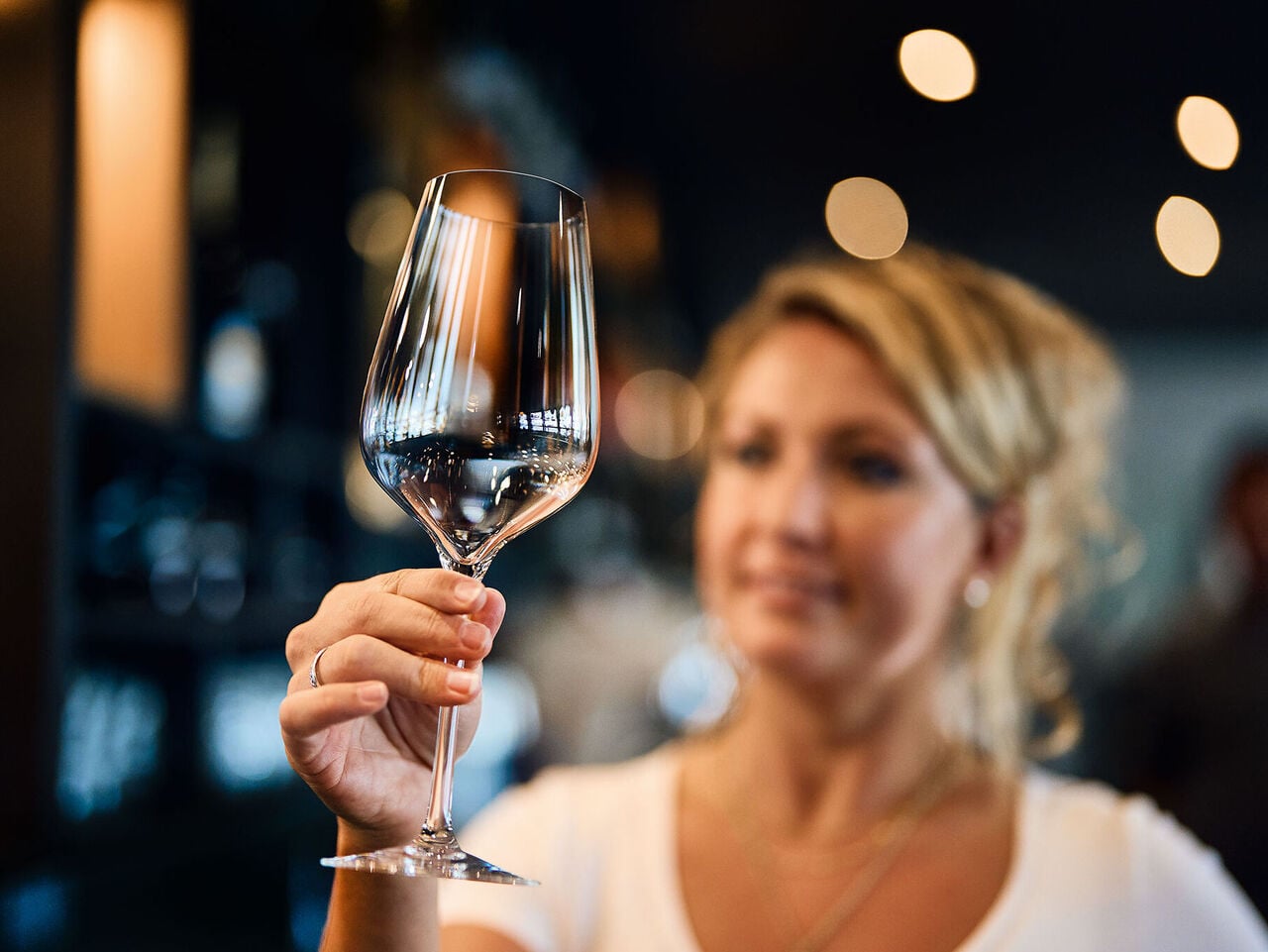 Lavage des verres : les restaurateurs adorent les verres brillants ! Une serveuse du restaurant vérifie si le verre à vin lavé est impeccablement propre